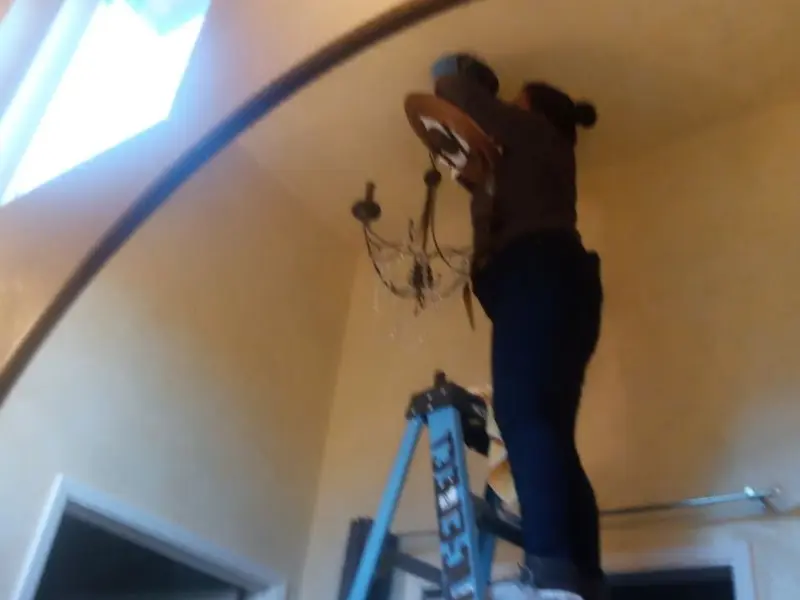Electrician installing a chandelier in a Knoxville residence